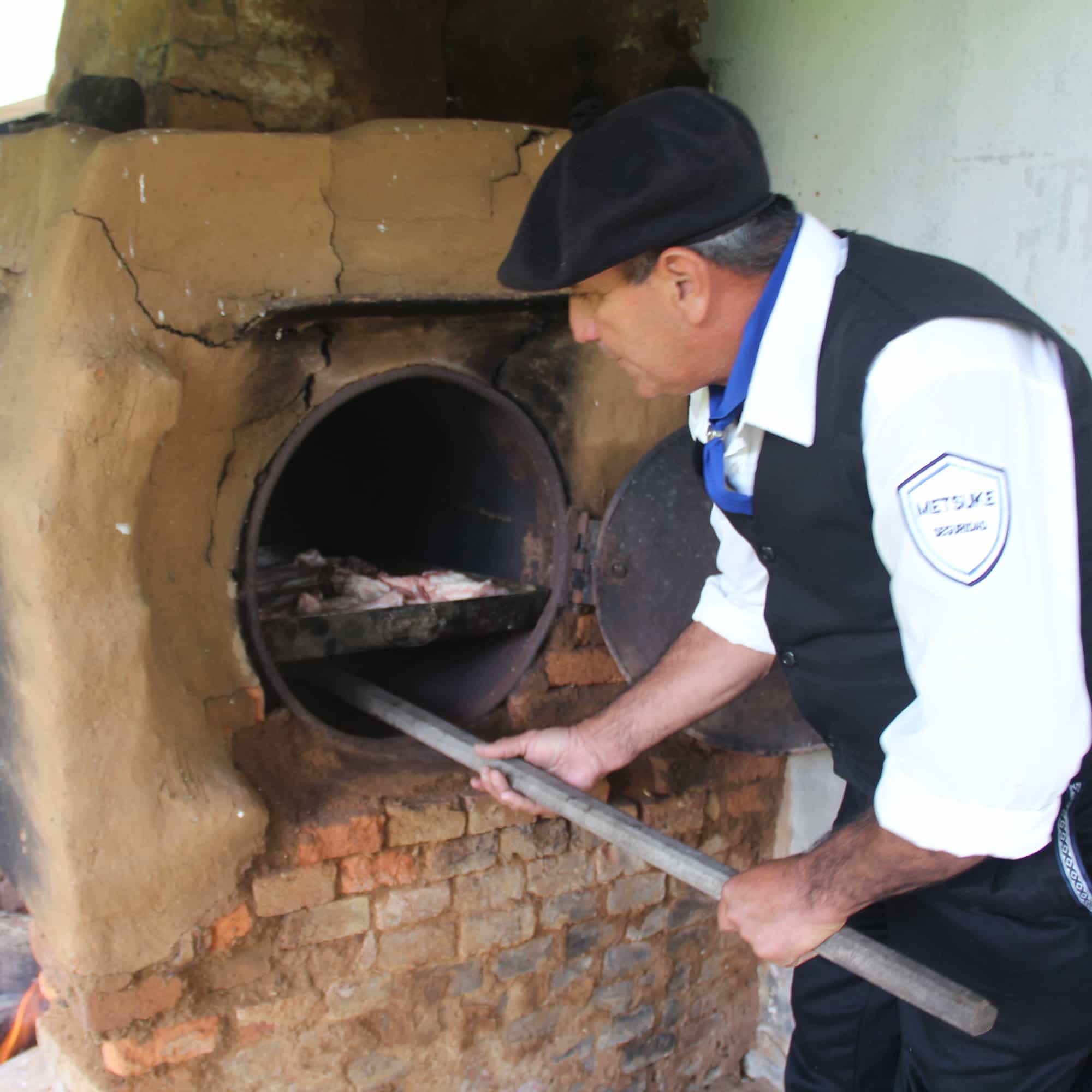 photo of Aurelio handling the wood-fired oven
